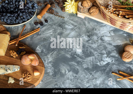Ancora in vita con diverse varietà di formaggio sul vassoio in legno, dadi, grissini, uva, uva passa, vino cavatappi Foto Stock