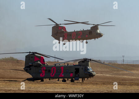 Un U.S. Esercito UH-60 Black Hawk elicottero dalla California esercito nazionale della guardia Bravo Company, 1° Battaglione, 126Reggimento di aviazione, terre, mentre il prelievo e facendo scendere i vigili del fuoco in un helibase, Sett. 12, 2019, in Red Bluff, California, pur sostenendo gli sforzi per contenere il Sud fuoco nel Tehama County. Sei Cal Guard elicotteri sono stati attivati per assistere enti federali e statali combattendo una coppia di incendi nella contea. (U.S. Air National Guard photo by Staff Sgt. Crystal Housman) Foto Stock