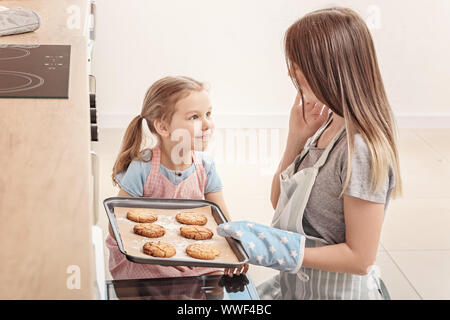 Bambina e la madre di lei i biscotti di cottura in cucina Foto Stock