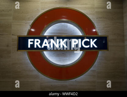 Close up London Underground roundel con il nome Frank Pick a Piccadilly la stazione della metropolitana di Londra. Foto Stock