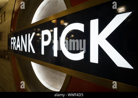 Close up London Underground roundel con il nome Frank Pick a Piccadilly la stazione della metropolitana di Londra. Foto Stock