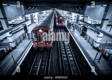 Due treni alla stazione di Aldgate East piattaforma sulla metropolitana di Londra Foto Stock