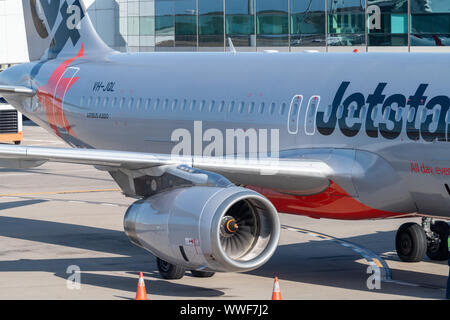 Brisbane, Australia - 15 Settembre 2019: Lato, ala e motore di un Jetstar Airbus A320 ancorata al gate terminale su asfalto presso l'aeroporto di Brisbane piano. Foto Stock