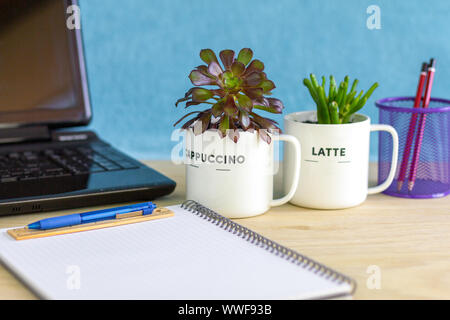 Impianti di casa riciclata in tazze da caffè sulla scrivania, casa e ufficio piante di ridurre lo stress, aumentare la creatività e la produttività come parte Foto Stock