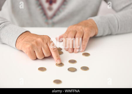 Donna anziana contare monete sul tavolo, primo piano Foto Stock