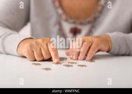 Donna anziana contare monete sul tavolo, primo piano Foto Stock