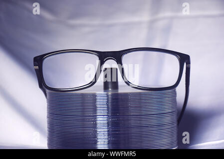 Uno degli occhiali sulla pila di dischi vuoti con panno crebbe sfondo. Foto Stock