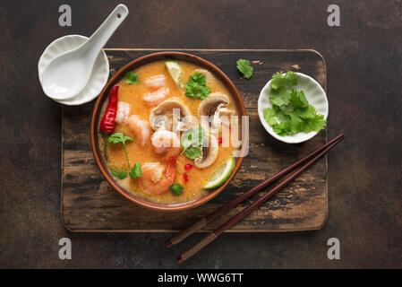 Tom Yum Kung zuppa, vista dall'alto, copia dello spazio. Tradizionale thai piccante asiatica di latte di cocco Zuppa di gamberetti - Tom Yam soup. Foto Stock