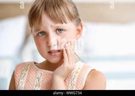 Bambina soffre di mal di denti a casa Foto Stock