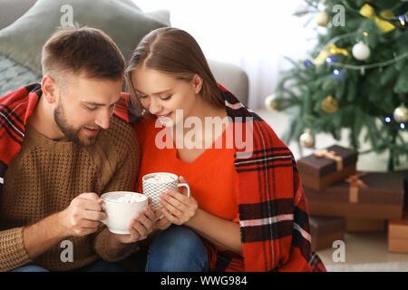 Coppia giovane di bere cioccolata calda a casa Foto Stock