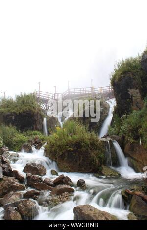 Piccole cascate mostrato con motion blur tra lussureggianti verdi e alcune rocce sulla strada per le Cascate del Niagara la Caverna dei Venti tour Foto Stock