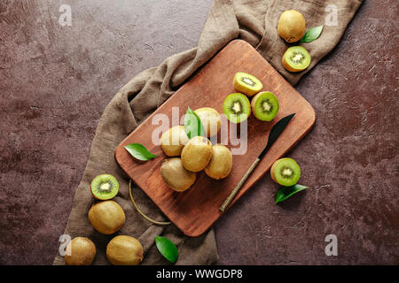 Tagliere con gustosi kiwi sul tavolo Foto Stock