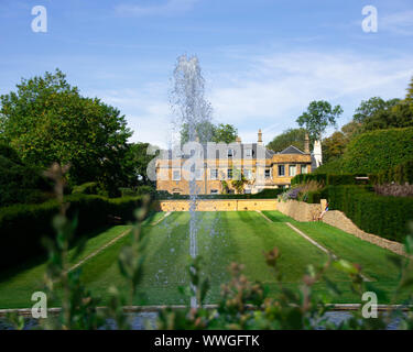 Una bellissima Country Manor House situato nel cuore di Somerset visto attraverso una fontana di acqua in primo piano Foto Stock