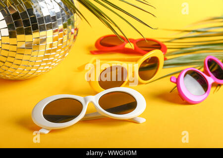 Diversi Eleganti occhiali da sole con palla da discoteca e foglie tropicali  sul colore di sfondo Foto stock - Alamy
