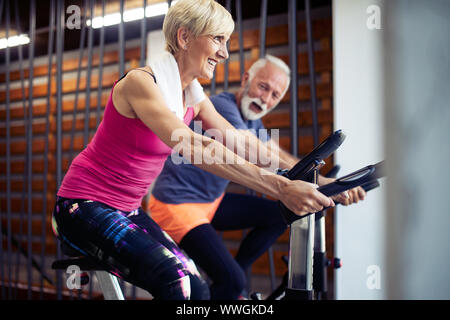 Felice senior di persone facendo indoor bike in un fitness club Foto Stock