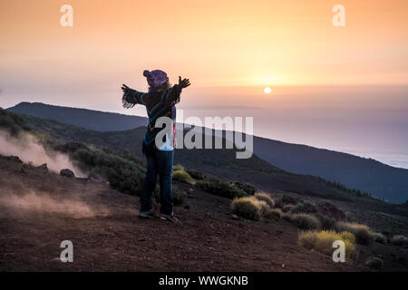 Le persone che si godono la natura aperta alla montagna durante il tramonto - donna attiva in outdoor le attività per il tempo libero con le braccia aperte - di libertà e di uno stile di vita alternativo Foto Stock