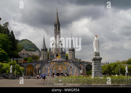 Basilica dell Immacolata Concezione della Beata Vergine Maria di Lourdes, Francia, sotto le nuvole scure Foto Stock