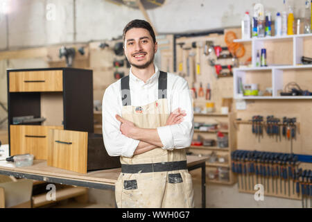 Mobili fabbrica, piccole aziende e persone concetto - Ritratto di un sorridente lavoratore di sesso maschile in fase di fabbricazione Foto Stock