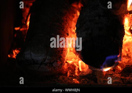 Primo piano della legna da ardere bruciare nel fuoco. Estate Chalet Caminetto fiammante. Serata di relax dal fuoco di legna. Foto Stock