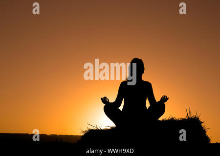 Silhouette di donna facendo yoga Foto Stock