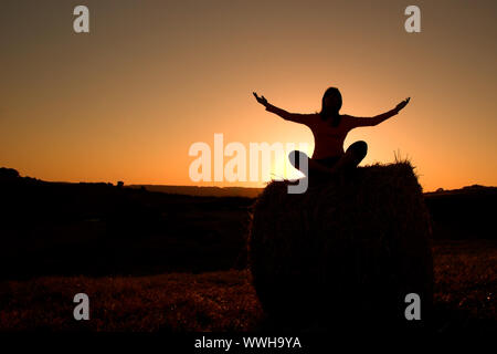 Silhouette di donna facendo yoga Foto Stock