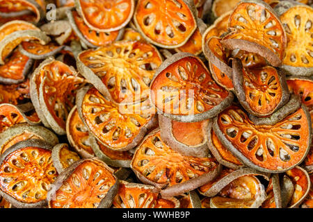 Close up affettato e essiccato Aegle marmelos bael o frutta. Bangkok Chinatown, Thailandia. Foto Stock