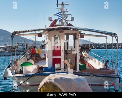 In dotazione in barca a vela con bandiera greca ormeggiata in porto vecchio di Naoussa in Grecia sulla giornata di sole sotto il cielo blu Foto Stock