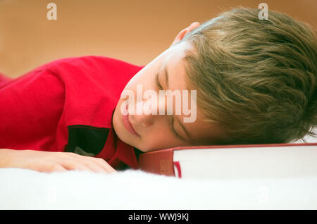 Giovane ragazzo si è addormentato dopo un duro studiare Foto Stock