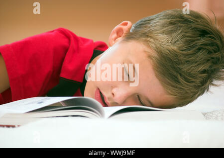 Giovane ragazzo si è addormentato dopo un duro studiare Foto Stock