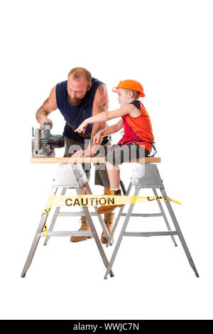 Carino figlio aiuta papà il taglio di una trave di legno con un pesante sega circolare come egli indicando come farlo, isolata. Ragazzo seduto sulla tavola di legno Foto Stock