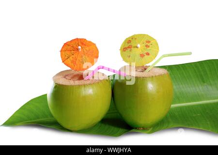 Il cocco bevande cocktail di paglia sulla gara banana leaf isolato Foto Stock