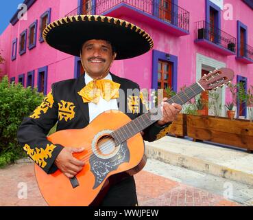 Charro Mariachi cantante suonando la chitarra in Messico houses background Foto Stock