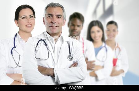 Competenza i capelli grigi medico infermiere multirazziale team fila su bianco Foto Stock