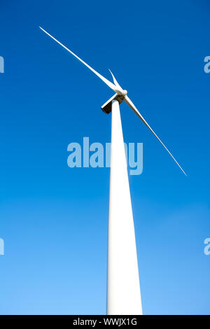 Generatore eolico mulino a vento nel cielo blu sullo sfondo Foto Stock