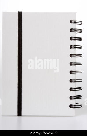 Notebook bianco con anello nero leganti, isolato su bianco, nero string per mantenerla in posizione di chiusura Foto Stock