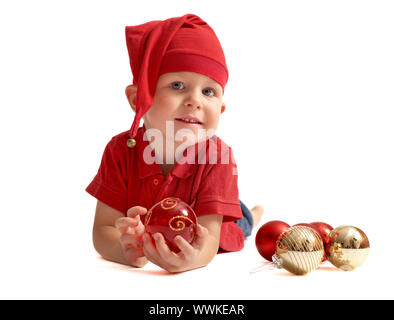 Carino il Natale di gnome. Piccolo Ragazzo in poco Santa o gnome vestiti giocando con albero di Natale giocattoli. Isolato su sfondo bianco. Foto Stock