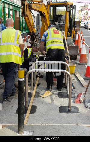 Lavoratori del consiglio che lavorano per l'installazione di nuove ringhiere per biciclette o di nuovi stand di parcheggio per biciclette in High Street a Killarney, County Kerry, Irlanda Foto Stock