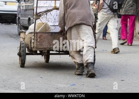 L'uomo spingendo un carrello di legno in Leh, Ladakh, India Foto Stock