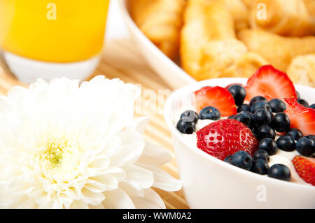 Colazione Leggera: succo d'arancia, croissant e bacche su un tavolo Foto Stock