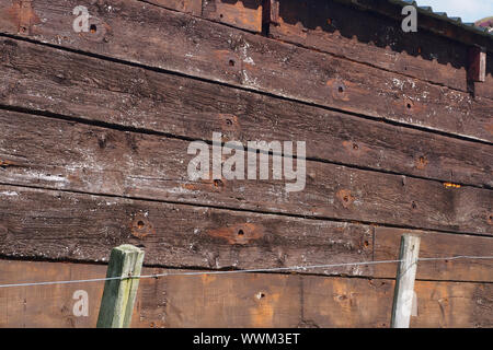 Una vista ravvicinata del legname rigenerati riutilizzati per costruire una capanna di legno che mostra la vecchia vite fori, il grano e lo spessore e la qualità dei pannelli in legno Foto Stock