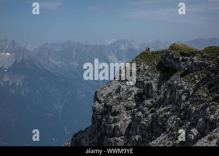 Due alpinisti seduto su un picco di montagna Foto Stock