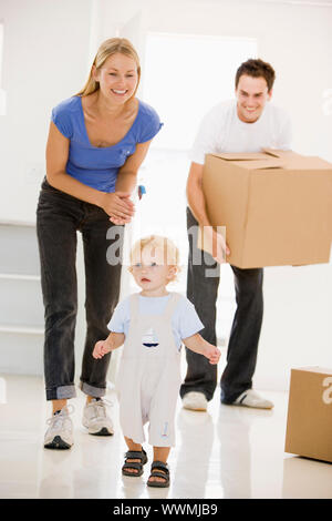 Famiglia in movimento nella nuova casa sorridente Foto Stock