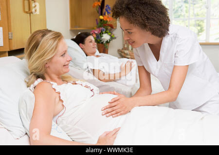 Controllo infermiere della donna incinta, ventre e sorridente Foto Stock