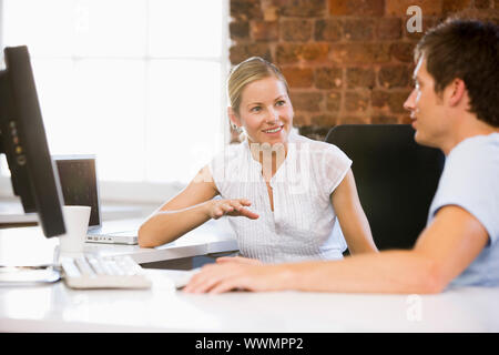 Due imprenditori in office di parlare e sorridente Foto Stock