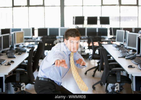 Imprenditore in piedi in atteggiamento di karate in sala computer Foto Stock