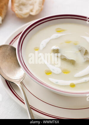 Ciotola di Vichyssoise con olio e pane rustico Foto Stock