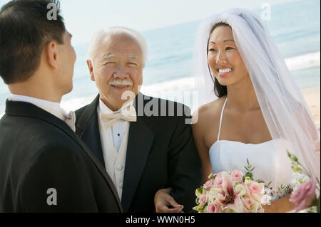 Sposa e il padre a braccetto con lo sposo Foto Stock