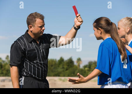 Arbitro di calcio espellendo il giocatore con la carta rossa Foto Stock