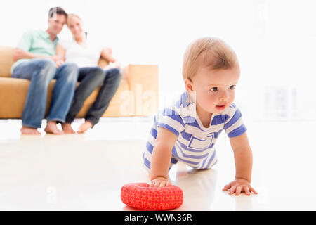 Matura in salotto con il bambino sorridente Foto Stock