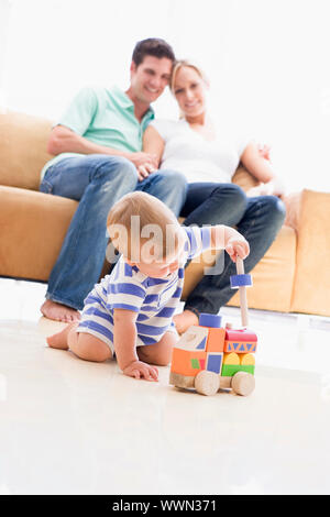 Matura in salotto con il bambino sorridente Foto Stock